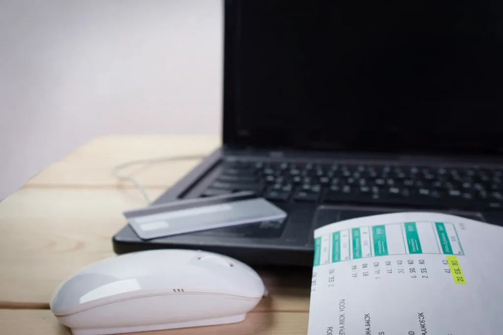 Itemized ride receipt beside laptop and corporate credit card on desk