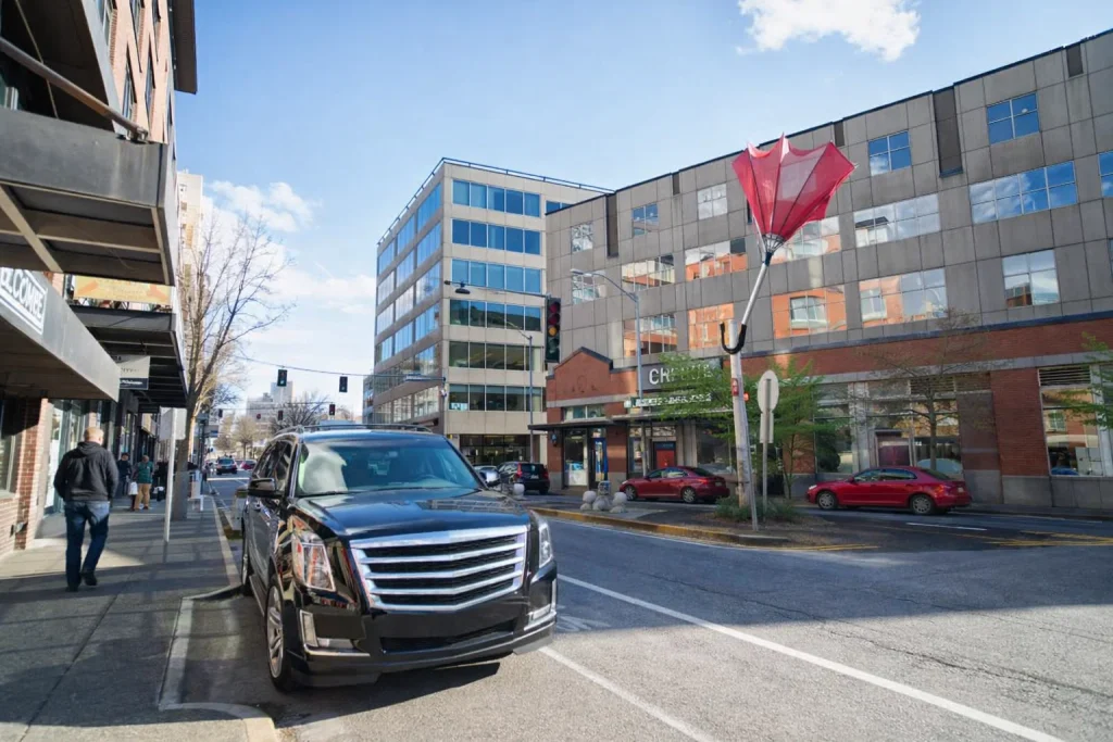 Executive sedan arriving near downtown Seattle office tower for a morning meeting