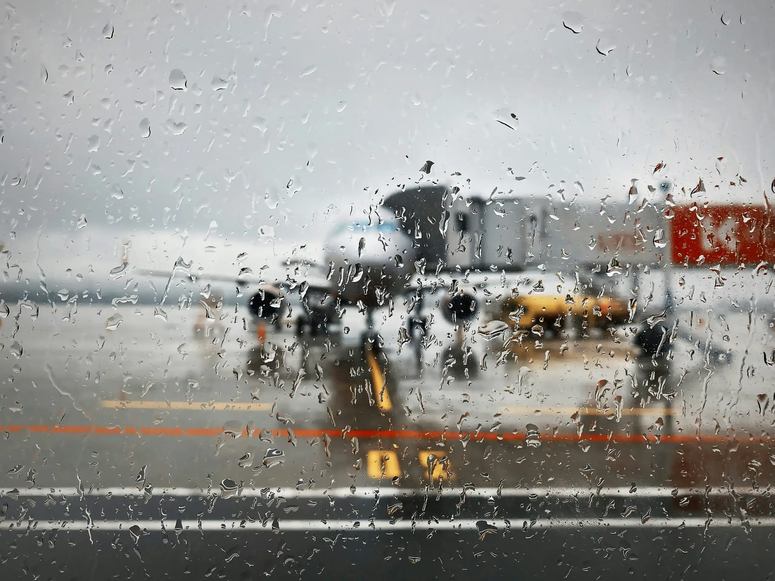 black luxury SUV limousine arriving at Seattle-Tacoma International Airport departure level on a rainy Seattle morning, reflections on pavement, professional chauffeur opening r...
