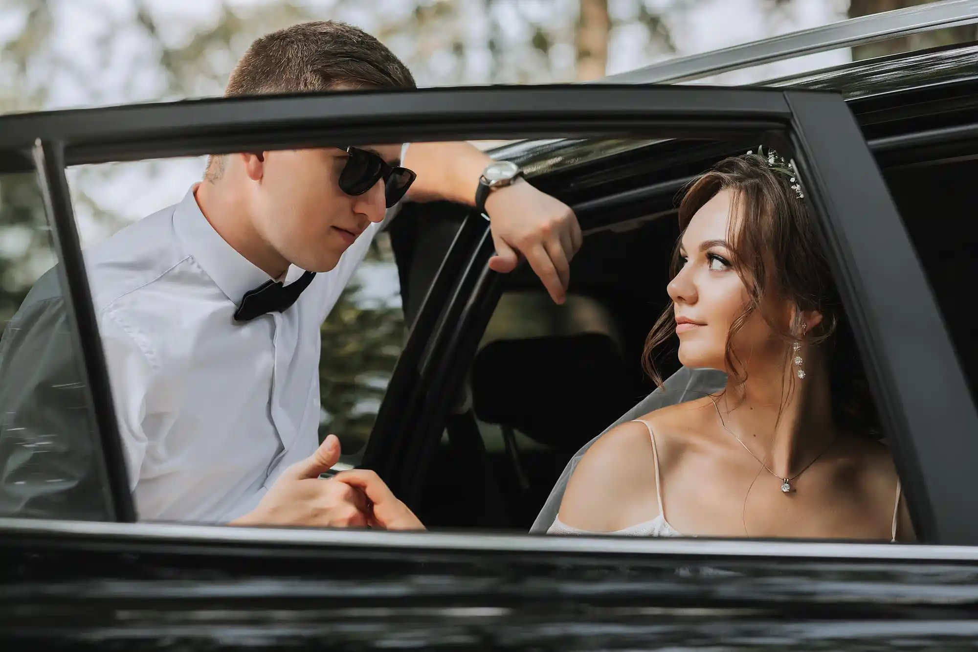 elegant white stretch limousine parked outside a historic Seattle wedding venue with floral arrangements, bride and groom preparing to enter, soft overcast Pacific Northwest light
