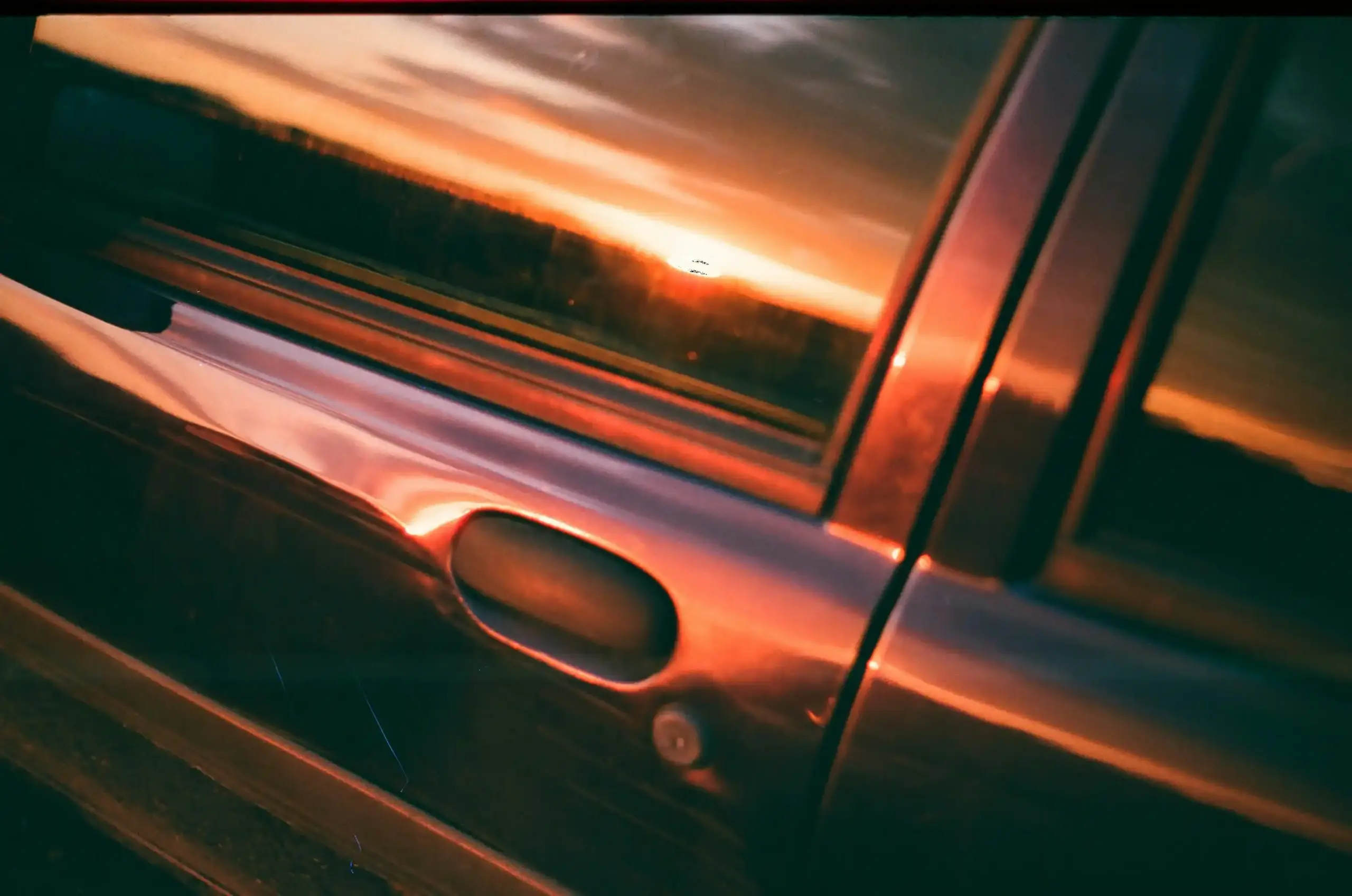 luxury black executive sedan arriving at a modern airport terminal at sunrise, professional chauffeur opening the rear door, travelers with sleek luggage, polished reflections o...