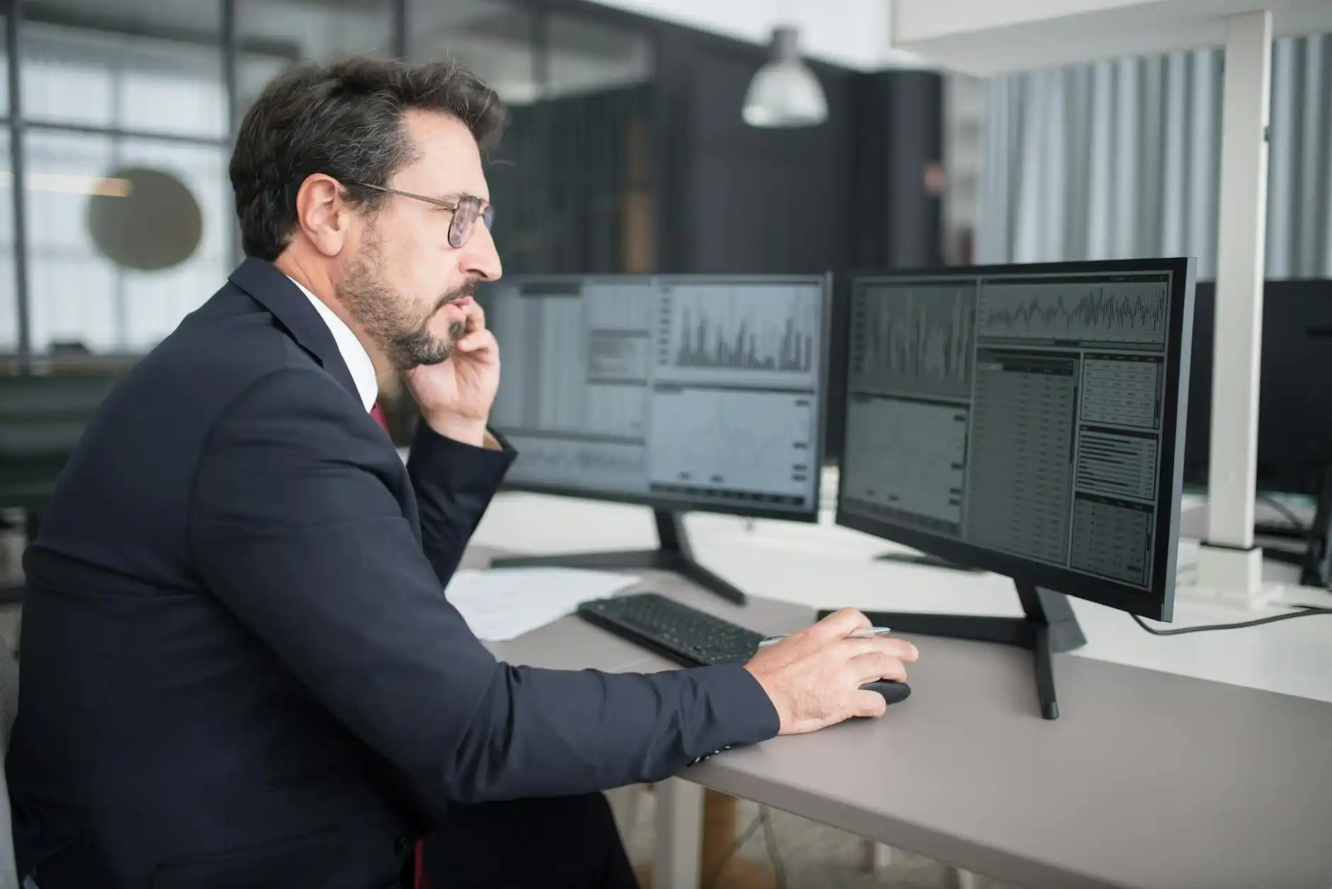 finance manager reviewing a clean monthly transportation invoice on dual monitors, organized digital dashboard with trip logs, modern office overlooking Seattle skyline