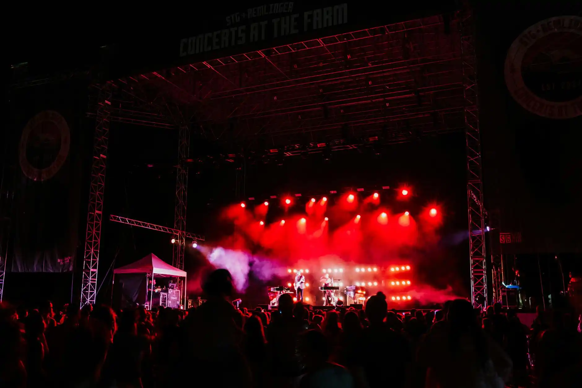 luxury limousine arriving at a Seattle concert venue at night, neon marquee lights reflecting on wet pavement, stylish group dressed for a night out laughing as they exit