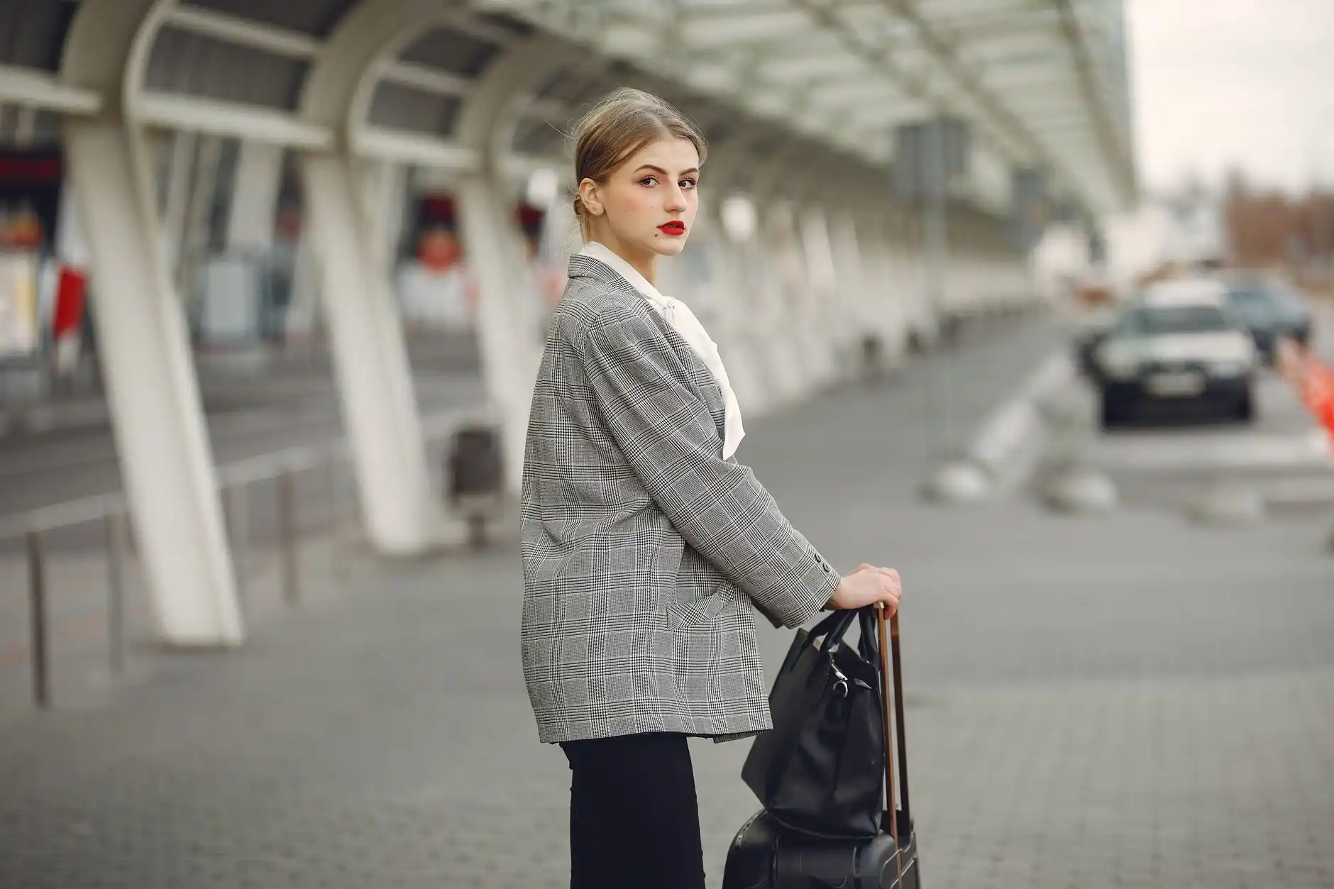 professional chauffeur in dark suit greeting travelers with luggage at Seattle-Tacoma International Airport arrivals area, modern terminal lighting, clear signage, upscale black...