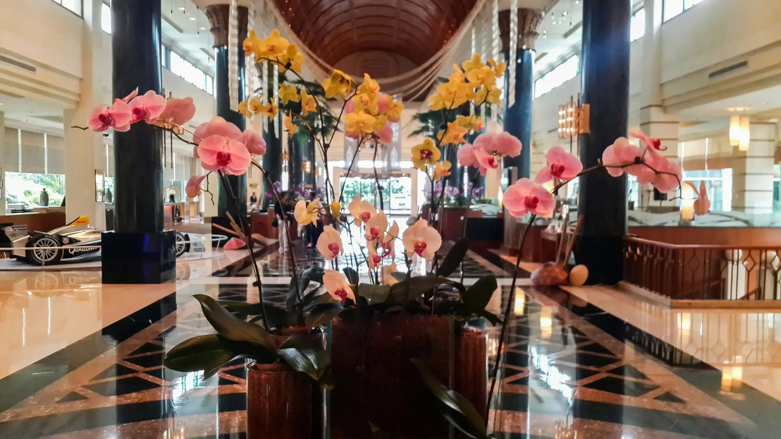 concierge desk inside an upscale Seattle hotel with a chauffeur itinerary on the counter, elegant floral arrangement, city-view windows, guest checking reservation details