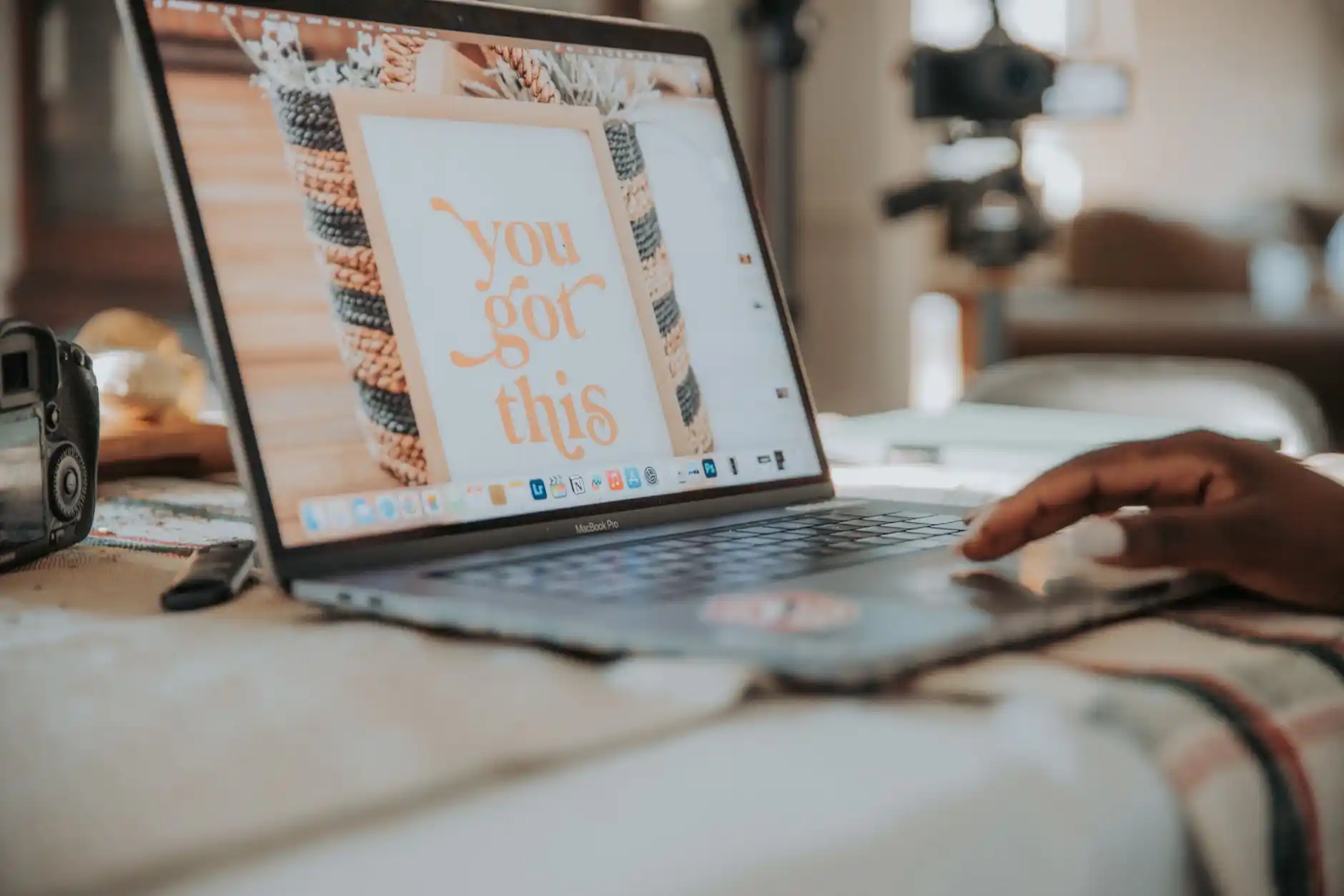 close-up of a person comparing transportation quotes on a laptop at a Seattle hotel lobby table, coffee cup beside printed rate sheets and a phone