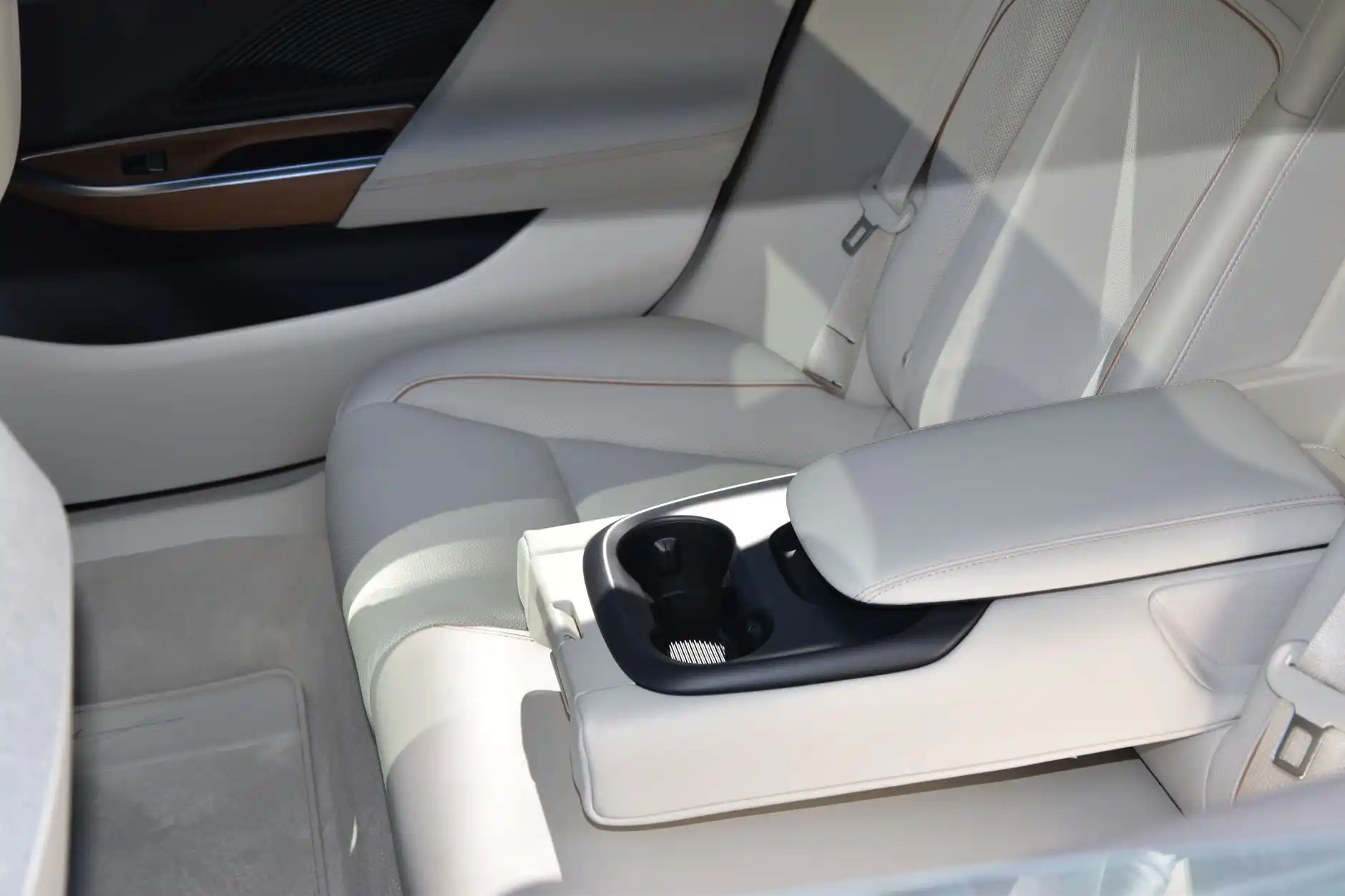 interior of luxury airport transfer SUV with soft ambient lighting, leather seats, carry-on luggage neatly stored, Seattle rain visible through tinted windows at night