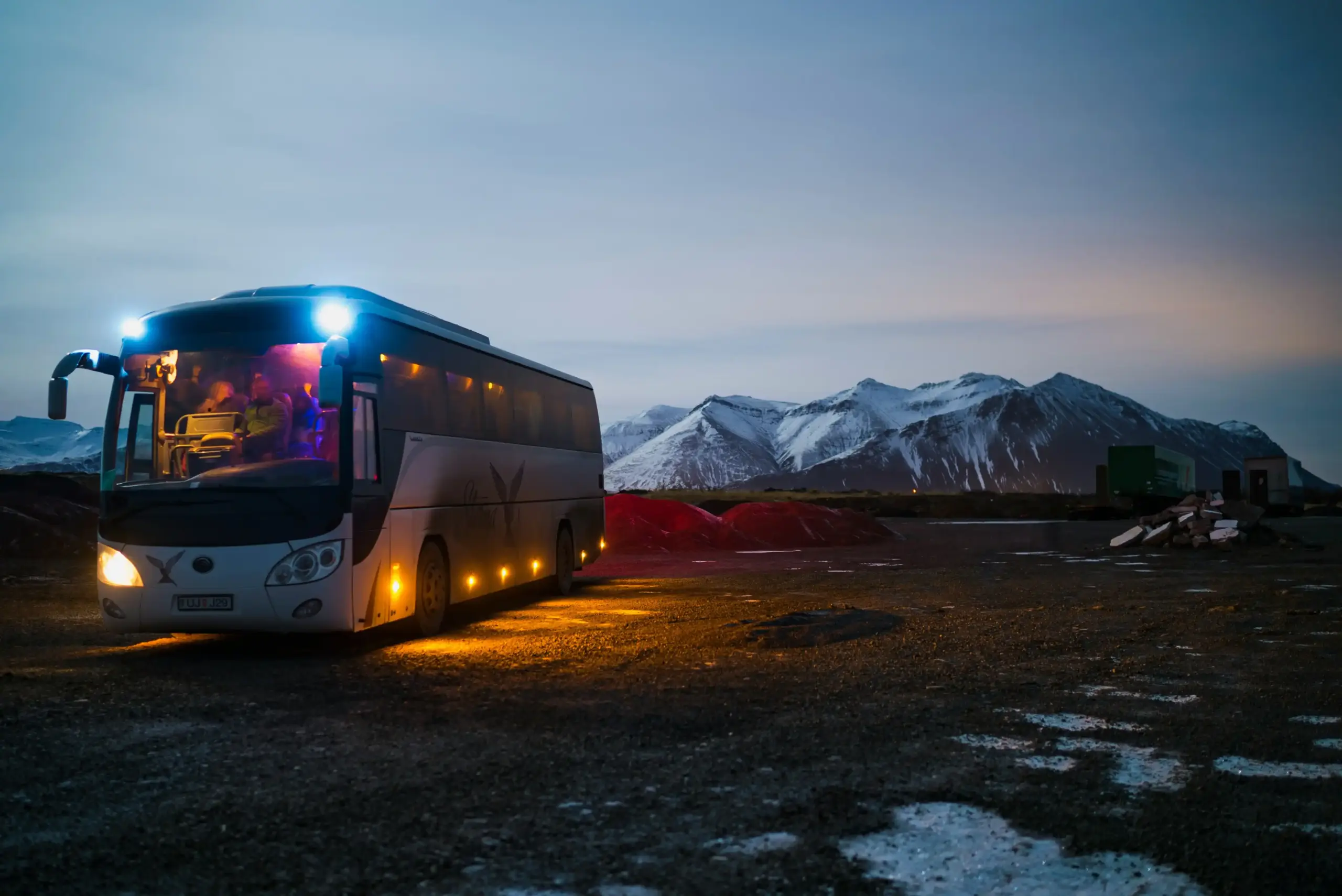 sleek black limo bus parked near the Seattle waterfront at sunset with city skyline reflections, professionally dressed group boarding for an evening event