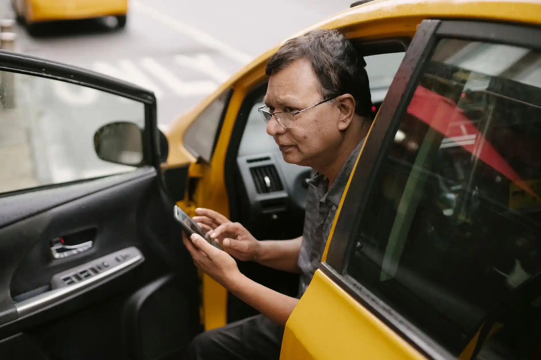 traveler reviewing a confirmed car reservation on smartphone beside carry-on luggage in upscale hotel lobby, modern seating, warm lighting, Seattle urban luxury atmosphere