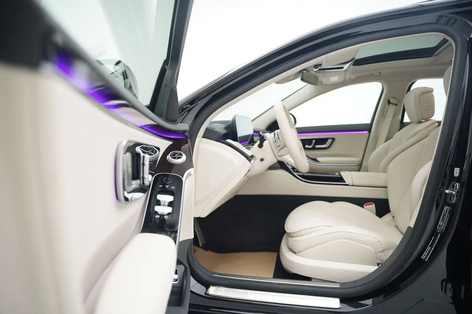 elegant interior of a luxury black SUV with tan leather captain seats, ambient lighting, bottled water, and city skyline visible through tinted windows