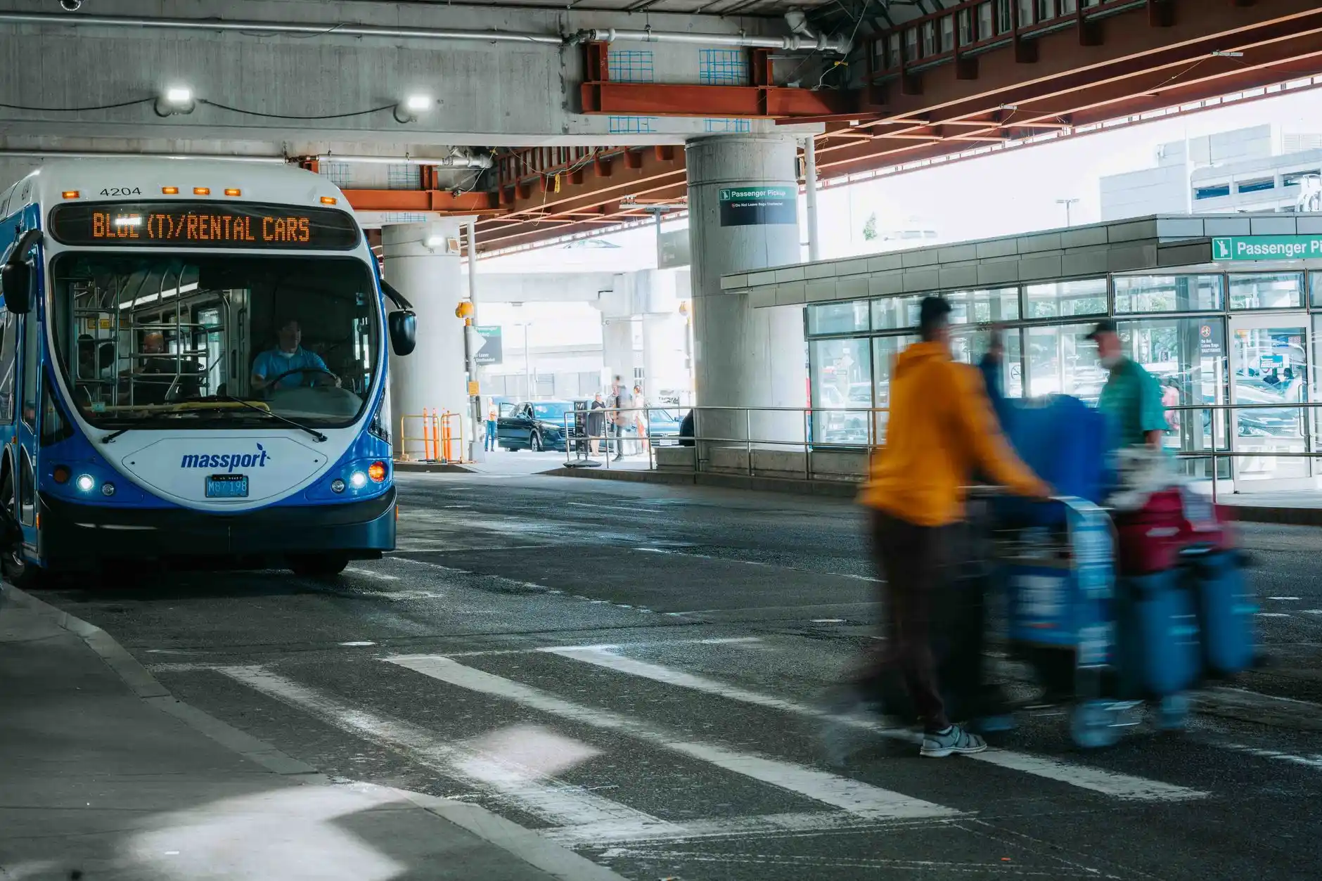 busy SeaTac airport arrivals curb with black executive car, passengers with suitcases, traffic control officers, illuminated terminal signage, and rainy Seattle pavement reflect...
