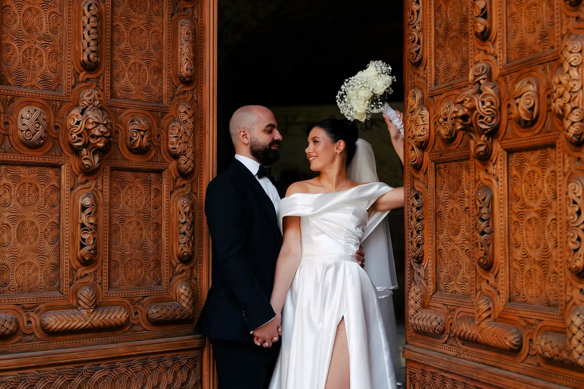 elegant wedding limousine arrival at a Pacific Northwest venue with evergreen trees, bride and groom near the door, chauffeurs assisting guests in formal attire