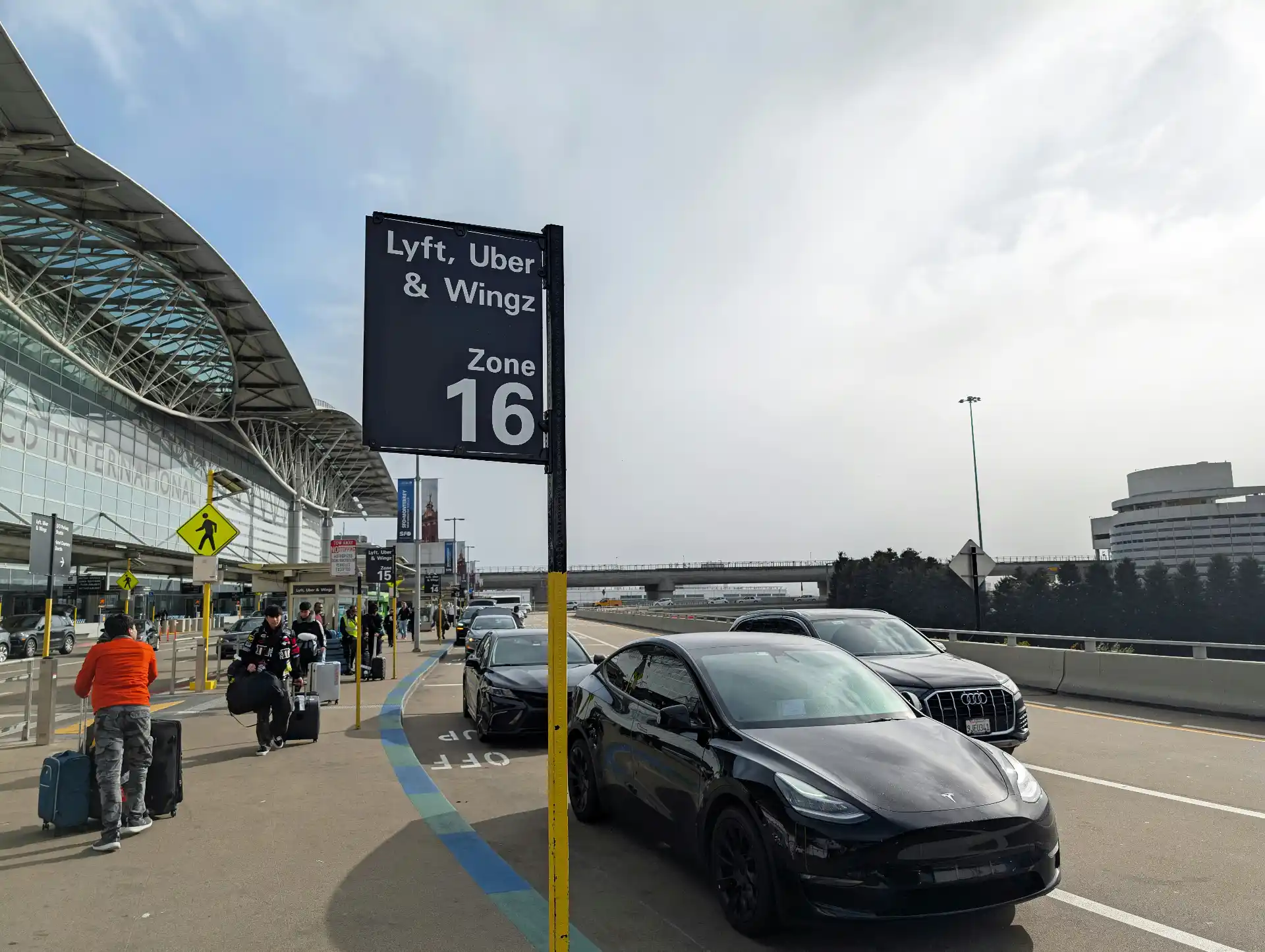 SeaTac Airport arrivals traveler comparing a waiting black car, rideshare pickup signs, taxi queue, and Link light rail wayfinding